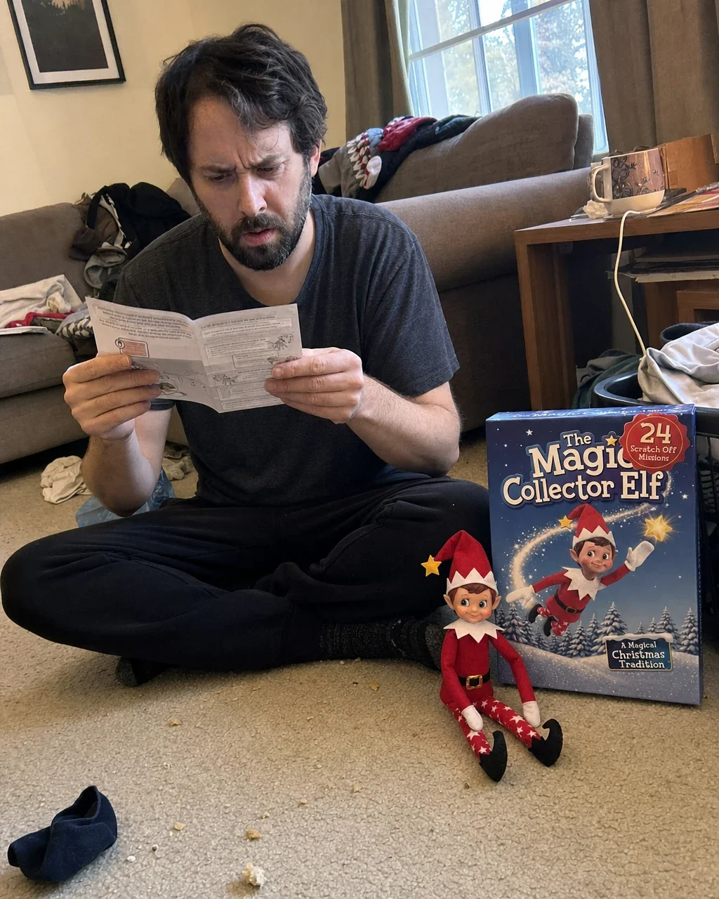 A father sitting on the floor reading the parent guide beside the open box